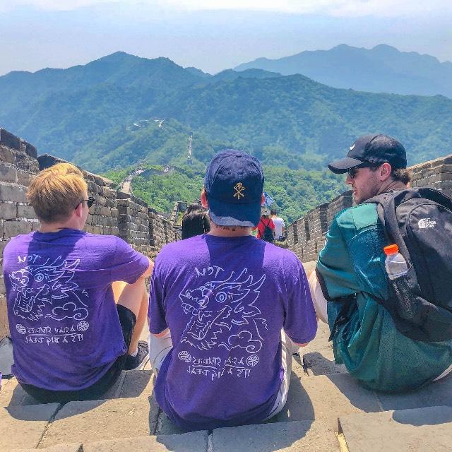 三个学生坐在中国的长城顶上