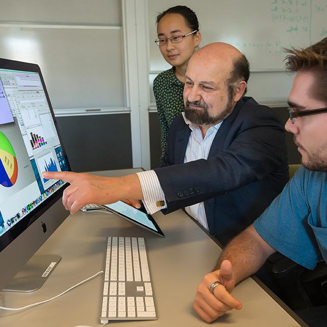 An instructors gestures toward a key datapoint within a data visualization on a computer screen