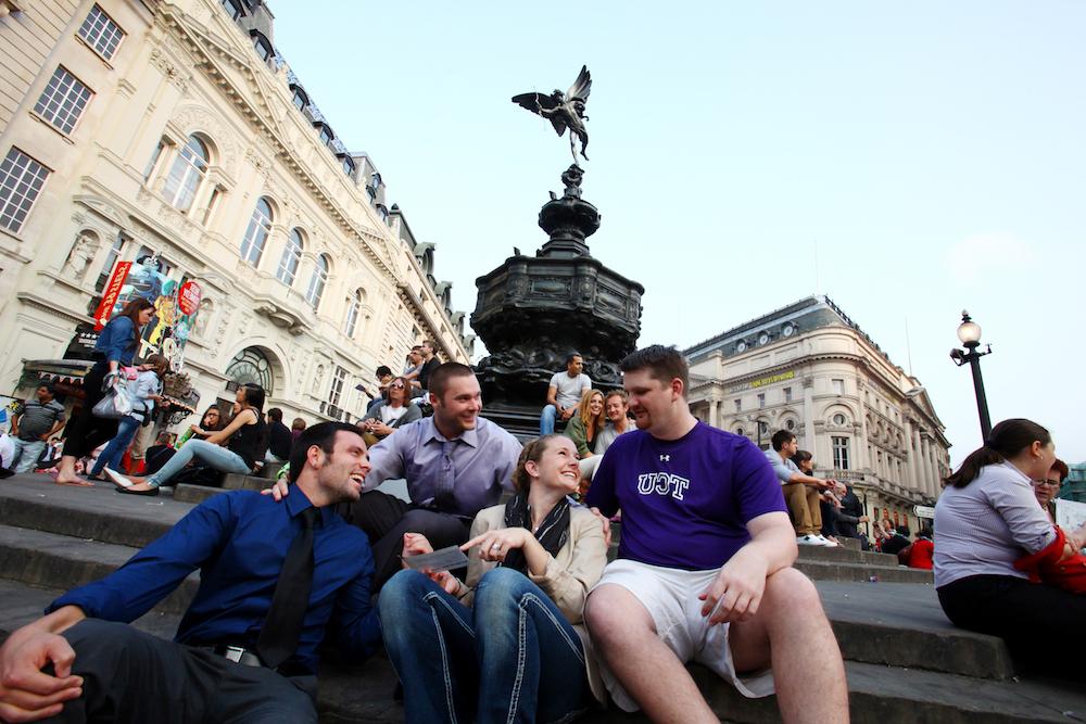 一小群TCU学生聚集在广场上一个华丽的喷泉前.